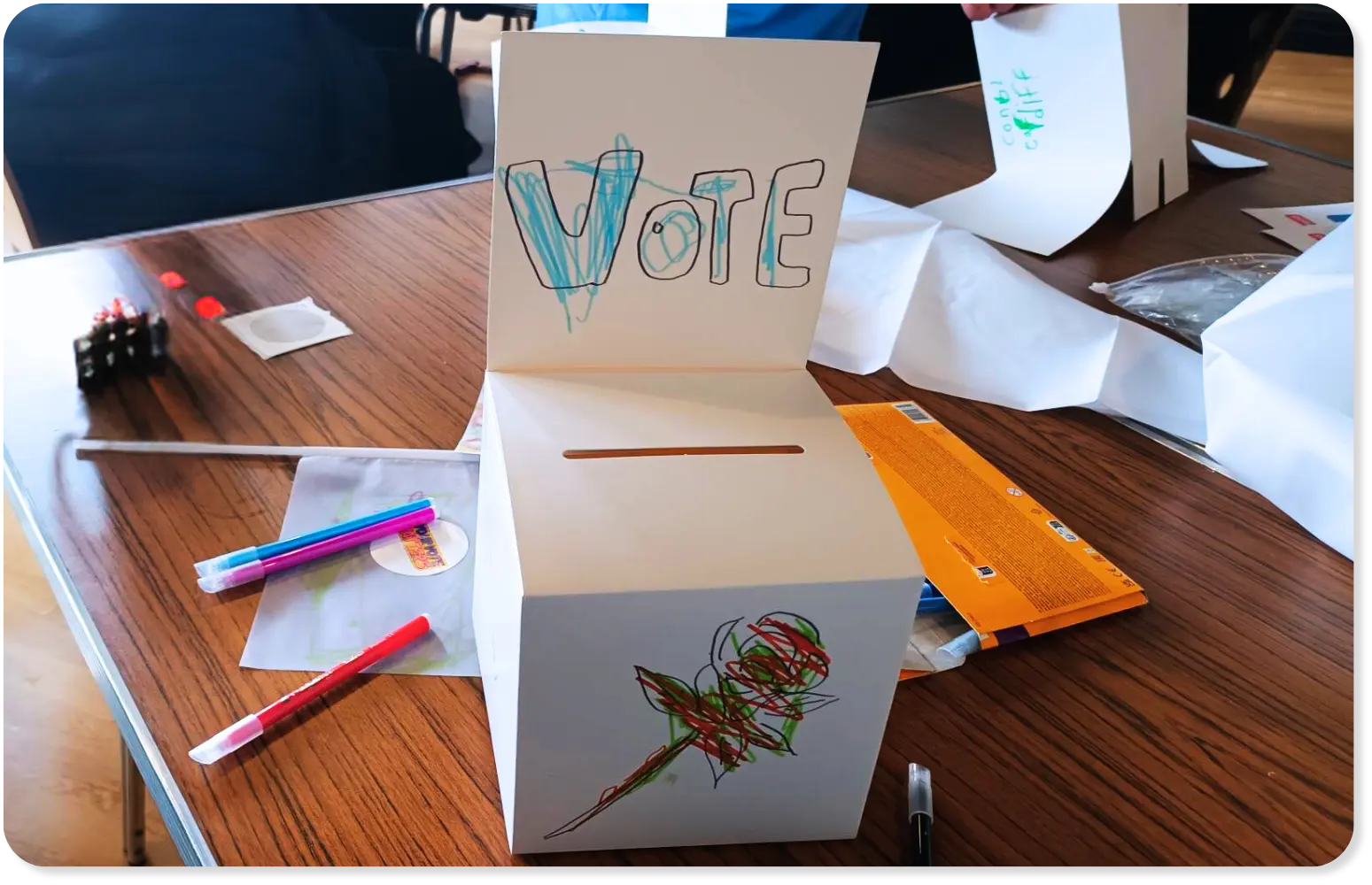 a handmade ballot box that says 'vote' with a slot to place voting ballot papers