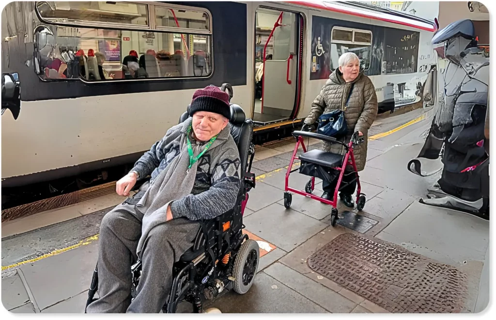 A person using a walking aid, and another person using a wheelchair, visiting Cardiff Central train station